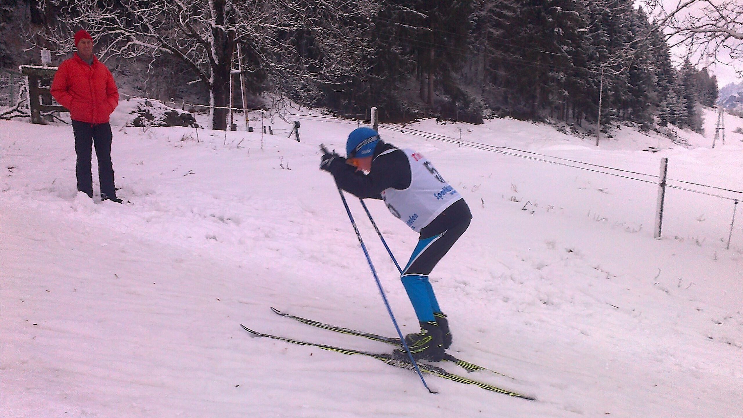 Jakob beim klassischen Skirennen im Schnee, mit Zuschauer im Hintergrund.
