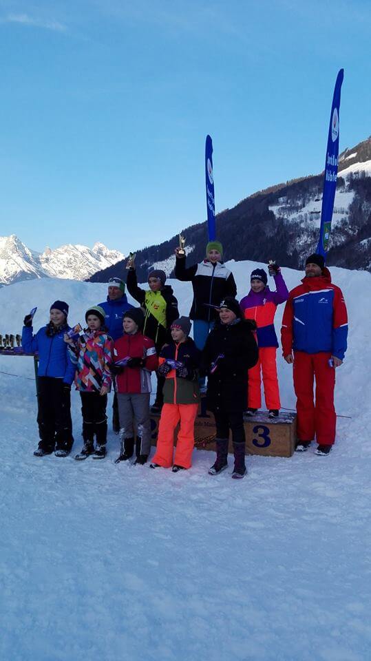 Kinder des Skiclubs Bruck feiern den 2. Rang beim Langlauf auf dem Siegerpodest.