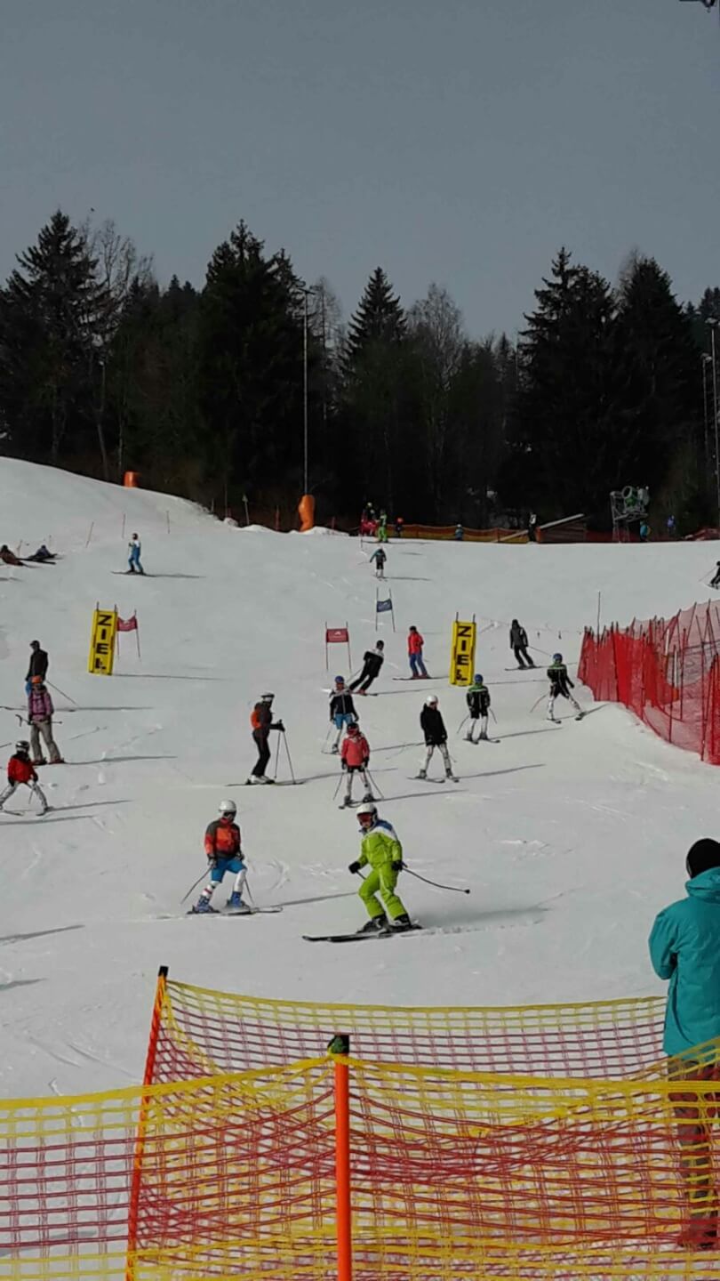 Skifahrer in bunten Anzügen nehmen am Kindercup in Zell am See teil.