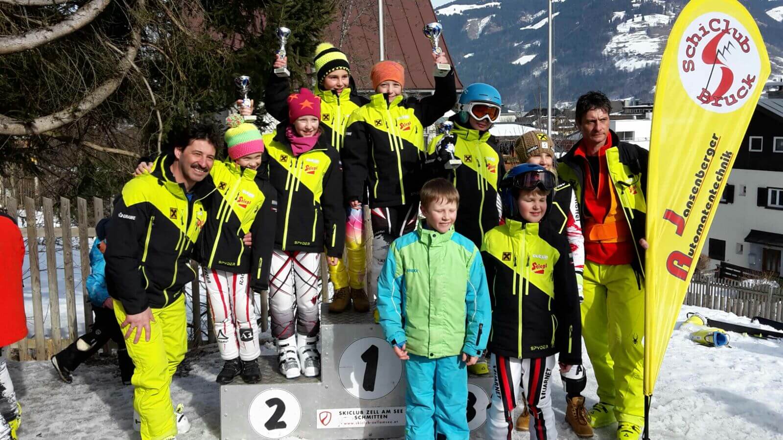Sieger:innen des Kindercups in Zell am See mit Pokalen und Skiausrüstung.