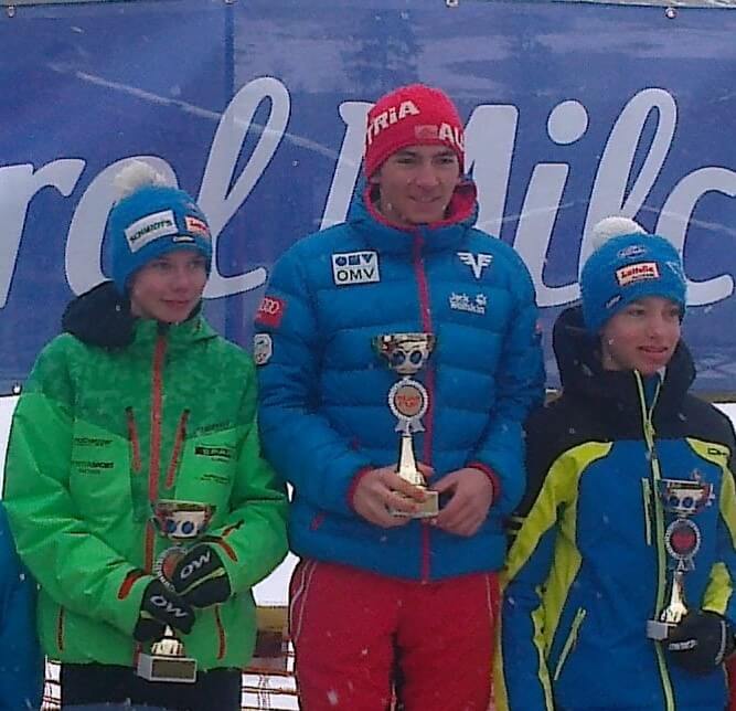Siegerehrung beim Sumi Cup West Biathlon, stolze Gewinner mit Pokalen in Winterkleidung.