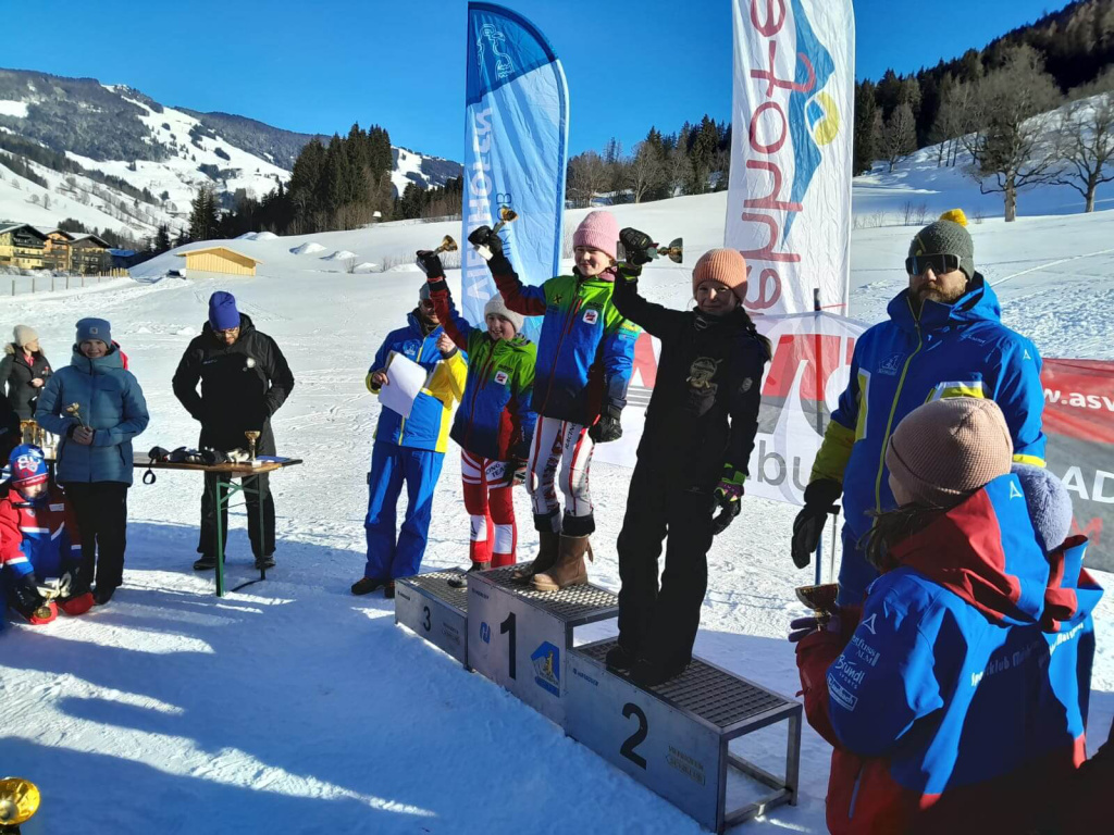 Siegerehrung beim KC Rennen in Hinterglemm mit strahlenden Kindern und Pokalen.