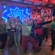 Skiclub-Mitglieder feiern in einer Hütte mit Pokalen und guter Stimmung