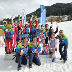 Kinder und Betreuer des Skiclub Bruck mit Pokalen bei der Siegerehrung im Schnee